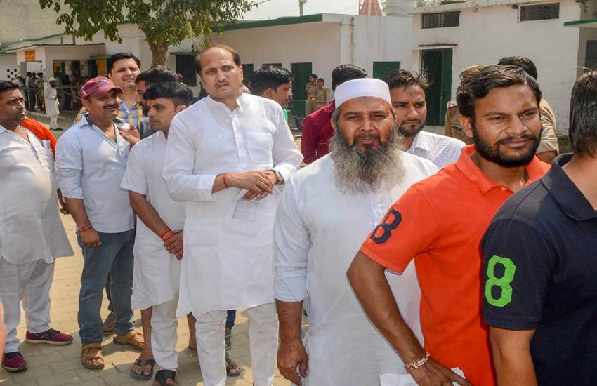 शामली में एक मतदान केंद्र पर मतदान करने पहुंचे बीजेपी विधायक सुरेश राणा (दाएं से चौथे)। ईवीएम में गड़बड़ी आने से कई बूथ पर मतादान में बाधा आई है। (फोटो सोर्स: पीटीआई)