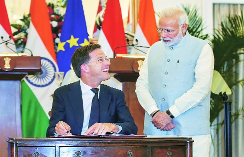 समझौते पर दस्तखत करते नीदरलैंड के प्रधानमंत्री मार्क रूटे को देखते प्रधानमंत्री नरेंद्र मोदी।
