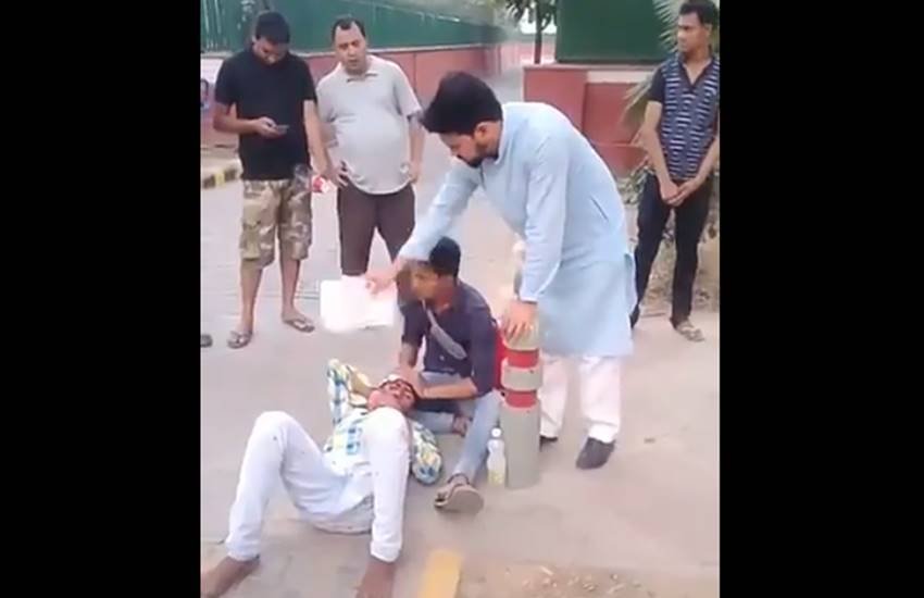 भाजपा सांसद अनुराग ठाकुर घायल शख्स पर पंखा झलते हुए। (वीडियो से लिया गया स्क्रीनशॉट)