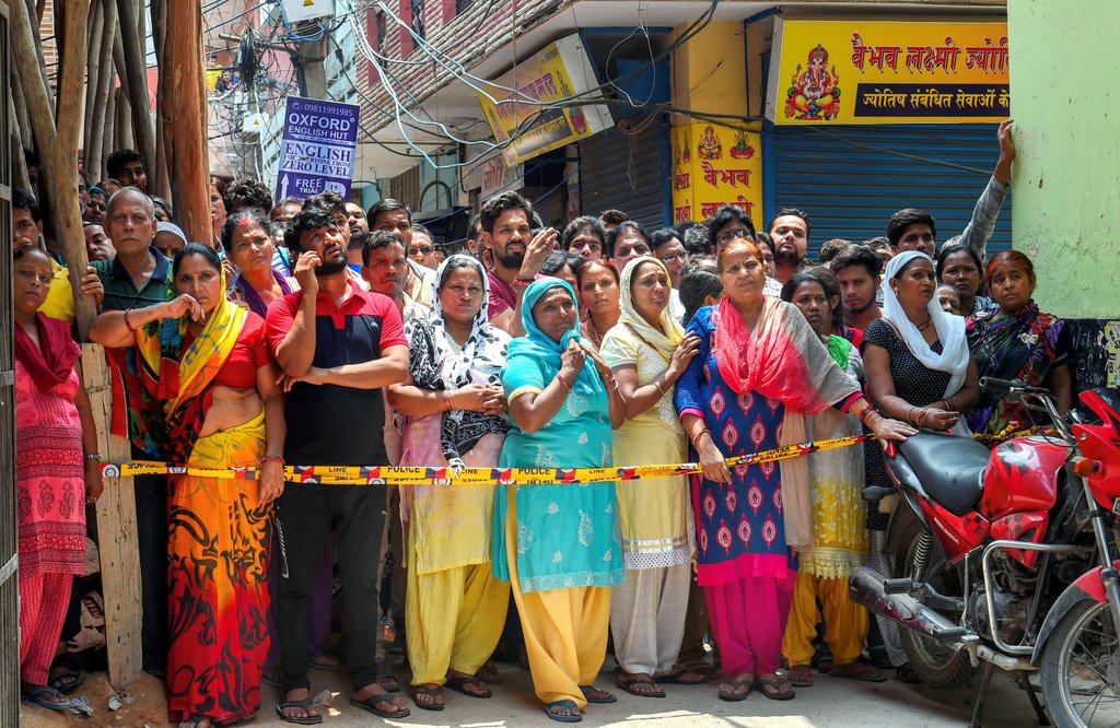 New Delhi: Neighbors stand near the house, where 11 members of a family- four men, three women and four girls- were found hanging from an iron grill, in Burari area of New Delhi on Sunday, July 1, 2018. (PTI Photo/Shahbaz Khan) (PTI7_1_2018_000111B)