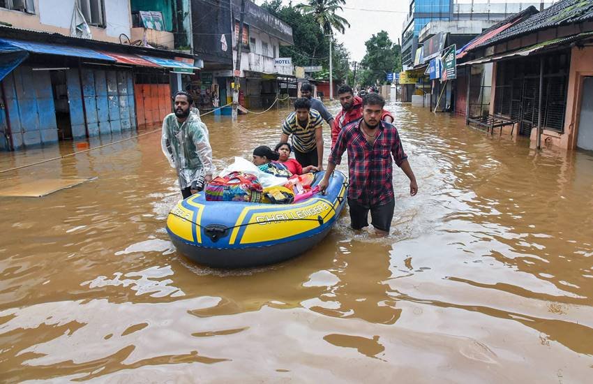 Kerala floods LIVE Update: केरल के अलुवा में लोगों को सुरक्षित स्‍थानों पर ले जाते राहत कर्मी। (Photo : PTI)