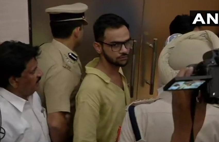 कार्यक्रमस्थल से खालिद को बाहर सही-सलामत लेकर जाती दिल्ली पुलिस। (फोटोः ANI)