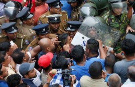 Supporters of Sri Lanka's newly appointed Prime Minister Mahinda Rajapaksa are pushed by members of the Special Task Force and the police in Colombo