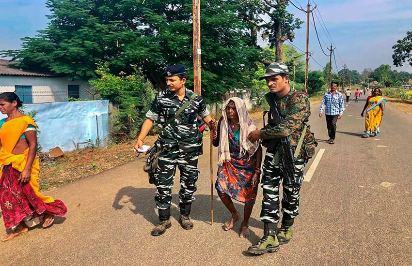 छत्‍तीसगढ़ के मरिगुदा में वृद्ध महिला को मतदान केंद्र की ओर ले जाते सीआरपीएफ के जवान। फोटो- पीटीअाई