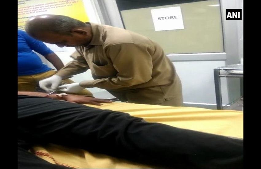 रोहतक के सिविल अस्पताल में मरीज को टांके लगाता हुआ चतुर्थ श्रेणी कर्मचारी। फोटो— एएनआई