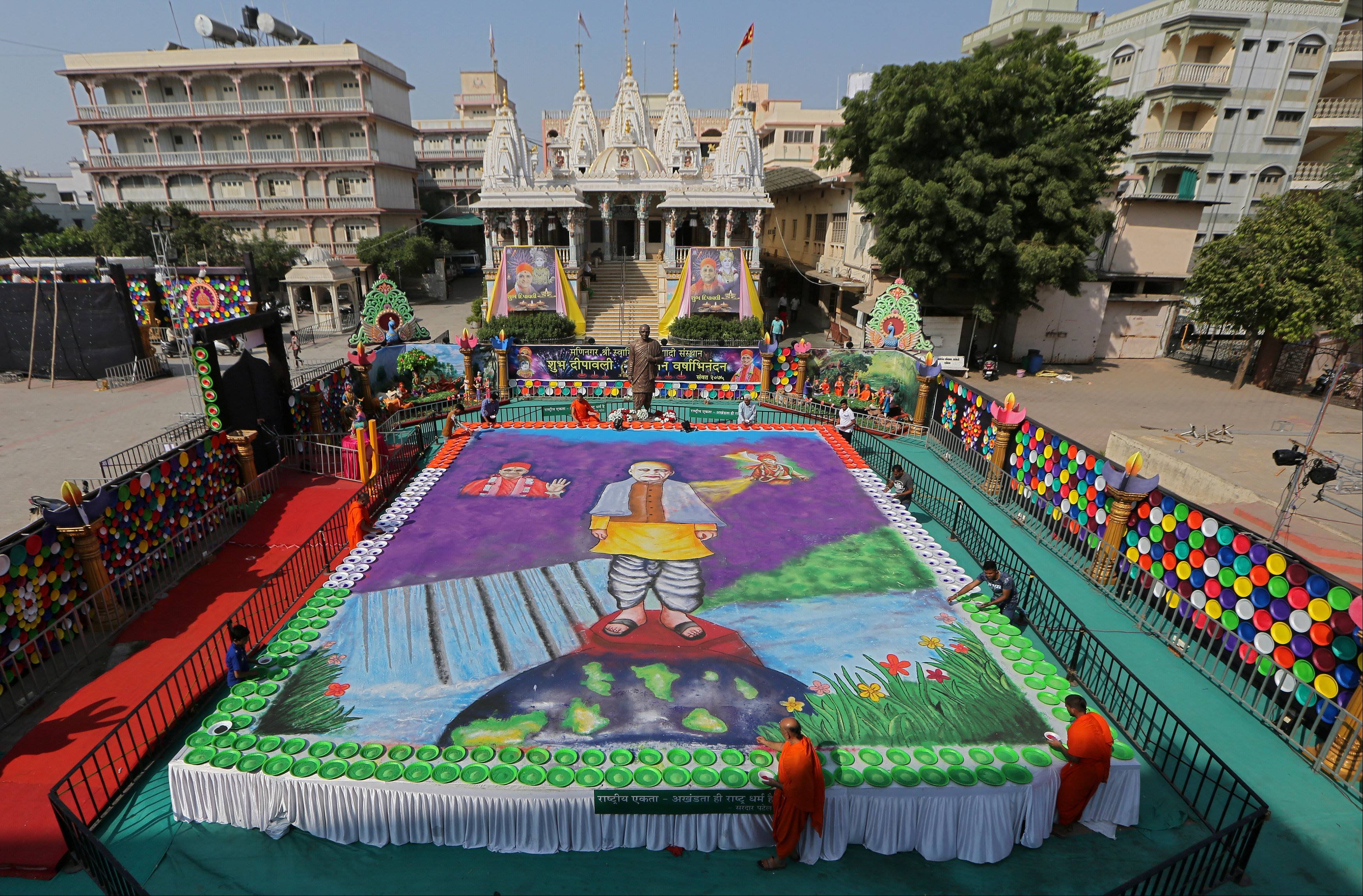 अहमदाबाद में मंदिरों के पुजारियों ने कलर पाउडर के जरिए शानदार रंगोली बनाई।