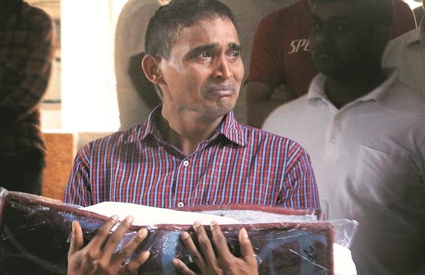 अपनी दो माह की बेटी का शव हाथों में लिए खड़े राजेश यादव. (एक्सप्रेस फोटो/अमित चक्रवर्ती)