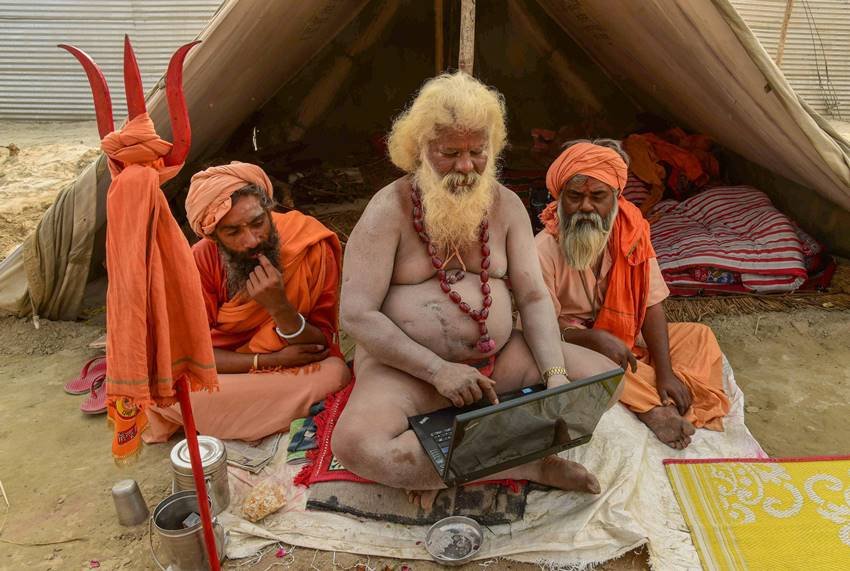 यहां अपने मंडली के साथ यह साधु लैपटॉप चलाते दिख रहे हैं।