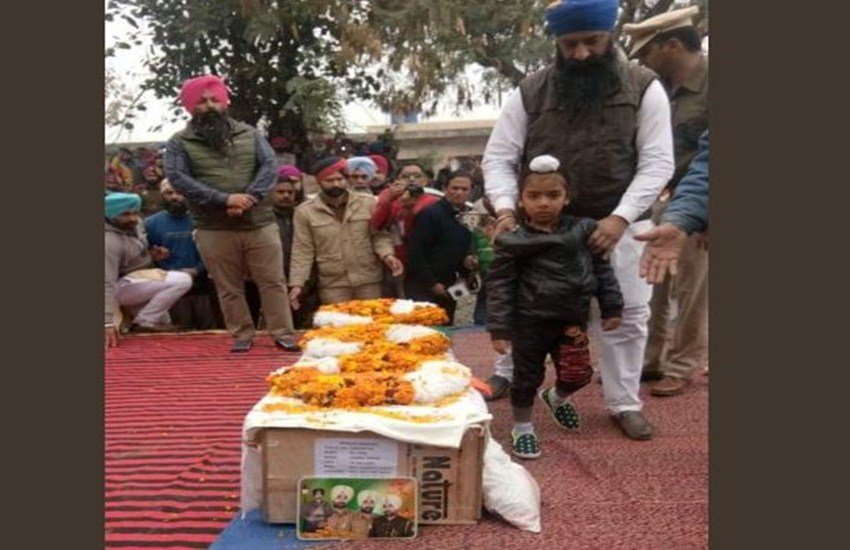 पुलवामा हमले में शहीद जयमाल सिंह के पार्थिव शरीर के साथ उनका 5 साल का बेटा। (फोटो क्रेडिट/हरप्रीत कौर ट्वीटर हैंडल)