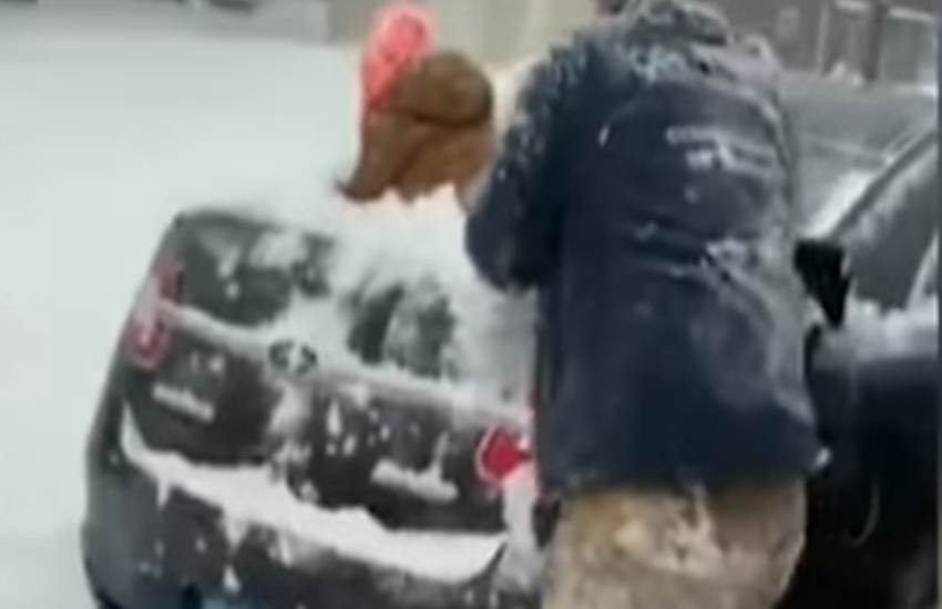 बेटे को वाइपर की तरह इस्तेमाल कर बर्फ हटाते पिता। (Photo: Video Grab)