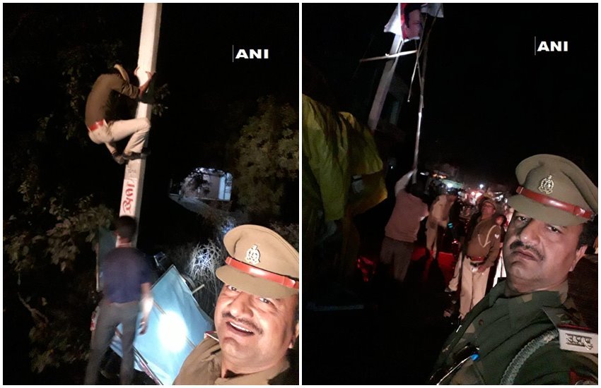 आचार संहिता लगने के बाद चुनावी पोस्टरों को हटाता पुलिसकर्मी और सेल्फी लेते एसआई 
फोटो सोर्स- ANI