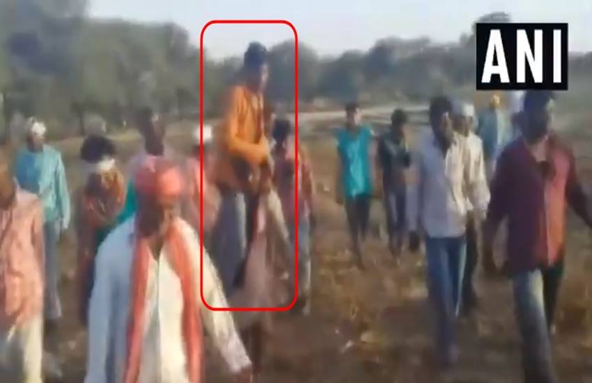 झाबुआ (मध्य प्रदेश) में कंधे पर पति को ले जाते पत्नि, फोटो सोर्स- ANI