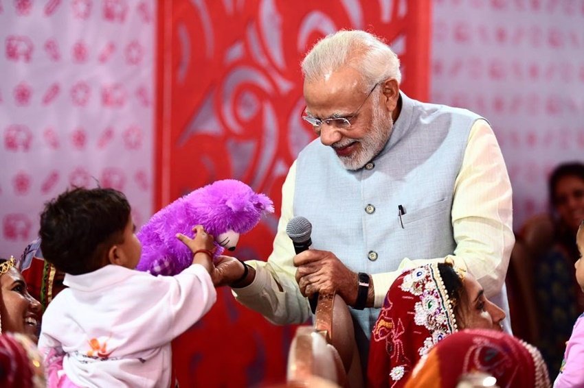 राजस्थान स्थित झुंझुनू में एक कार्यक्रम के दौरान बच्चे को गिफ्ट भेंट करते हुए पीएम मोदी।