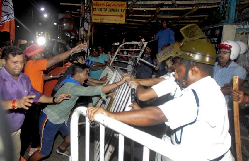 कोलकाता स्थित कलकत्ता विवि के गेट के बाहर पुलिस बैरिकेड तोड़ते और धक्का-मुक्की करते हुए बीजेपी समर्थक। (फोटोः एपी)