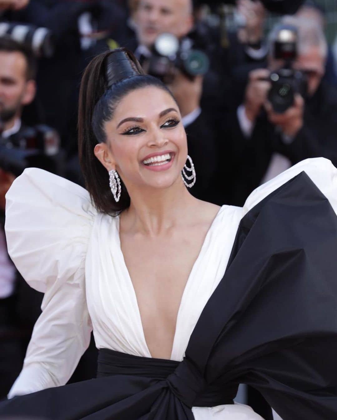 दीपिका ने पीटर डुंडास का ऑफ व्हाइट रंग का परिधान चुना। अभिनेत्री अपने मेकअप के साथ भी प्रयोग करती नजर आयीं, उन्होंने अपनी आंखों में गहरा काजल भर कर उसे तीखा नक्श दिया और सिर पर ऊंची पोनीटेल चोटी की।