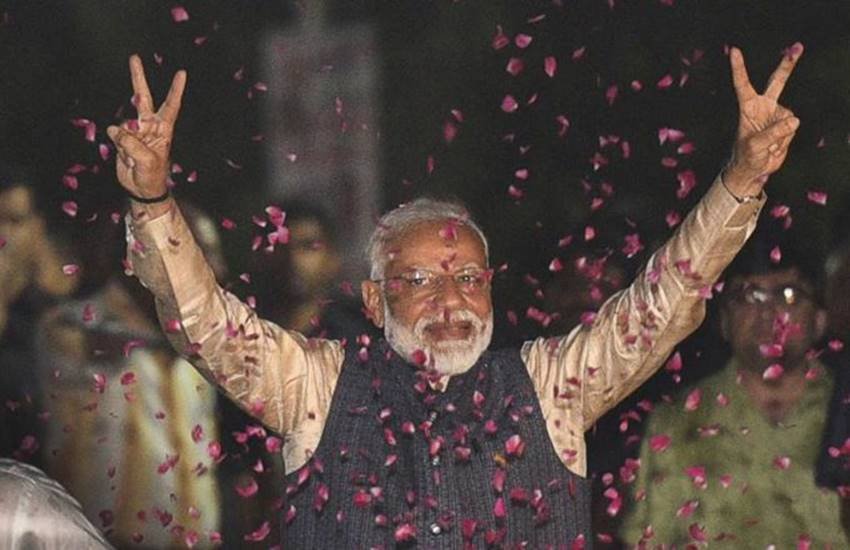 नई दिल्ली में गुरुवार शाम बीजेपी मुख्यालय पहुंचने पर विक्ट्री पोज देते हुए नरेंद्र मोदी की फाइल फोटो। (फोटोः पीटीआई)