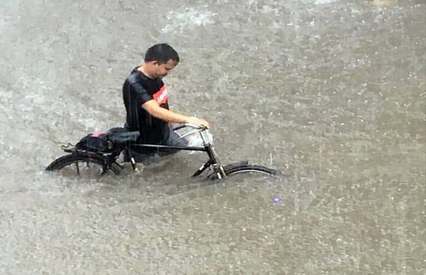 लोगों की साइकल भी आधी से ज्यादा पानी में डूबी गई थी। फोटो सोर्स: गुरमीत सिंह इंडियन एक्सप्रेस