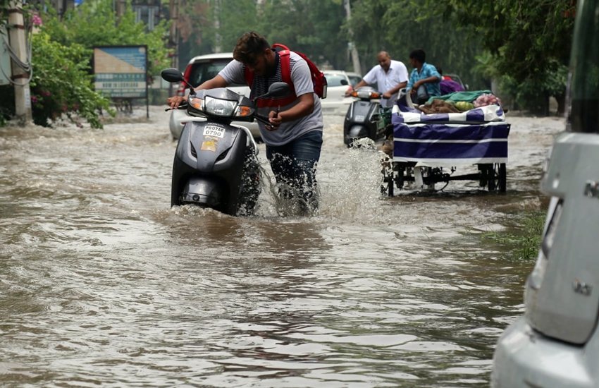 जलभराव की वजह से लोगों की गाड़ियां रास्ते में ही बंद हो गईं। फोटो सोर्स: गुरमीत सिंह इंडियन एक्सप्रेस