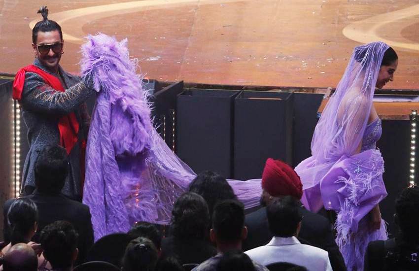 बुधवार को मुंबई में आयोजित इंटरनेशनल इंडियन फिल्म एकेडमी(IIFA 2019) अवार्ड्स का आयोजन हुआ। सितारों से सजी इस शाम में सबसे ज्यादा सुर्खियां बटोरीं दीपिका पादुकोण और रणवीर सिंह ने। इस कपल ने ना सिर्फ वहां अवार्ड जीते बल्कि लोगों के दिल भी जीते। दरअसल अवार्ड नाइट में एक वक्त ऐसा आया जब रणवीर सिंह पत्नी दीपिका की ड्रेस संभालते नजर आए। रणवीर दीपिका की ये तस्वीर मीडिया से लोकर सोशल मीडिया तक में छाई हुई हैं। रणवीर को उनके फैंस परफेक्ट पति की संज्ञा दे रहे हैं।(All Photo Source: AP)