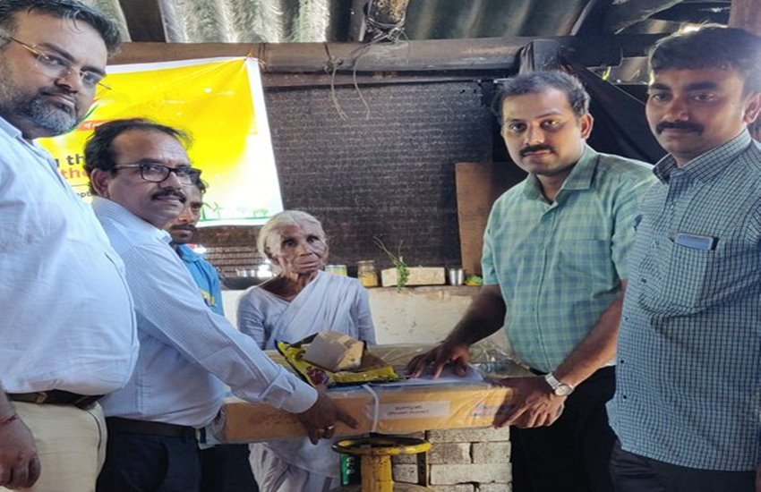 बुजुर्ग महिला को गैस कनेक्शन देते हुए सरकारी अधिकारी 
फोटो सोर्स- @BPCLCoimbatore