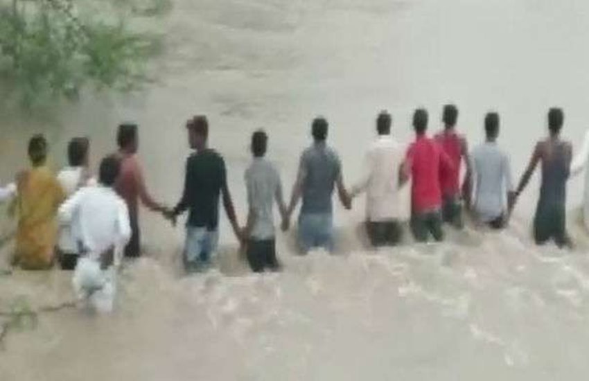 एमपी में बहते युवक को बचाते लोग 
फोटो सोर्स- ANI