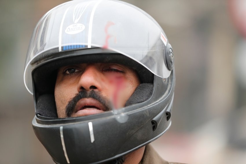 प्रदर्शनकारियों के हमले से बचने के लिए पुलिसवालों ने हेलमेट भी लगाए थे बावजूद उन्हें चोटें आईं।(Photo: REUTERS/Adnan Abidi)