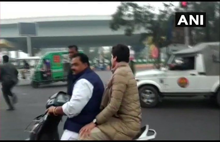 लखनऊ में पार्टी कार्यकर्ता की स्कूटी पर बैठकर जातीं कांग्रेस महासचिव प्रियंका गांधी (फोटो सोर्स- एएनआई) 