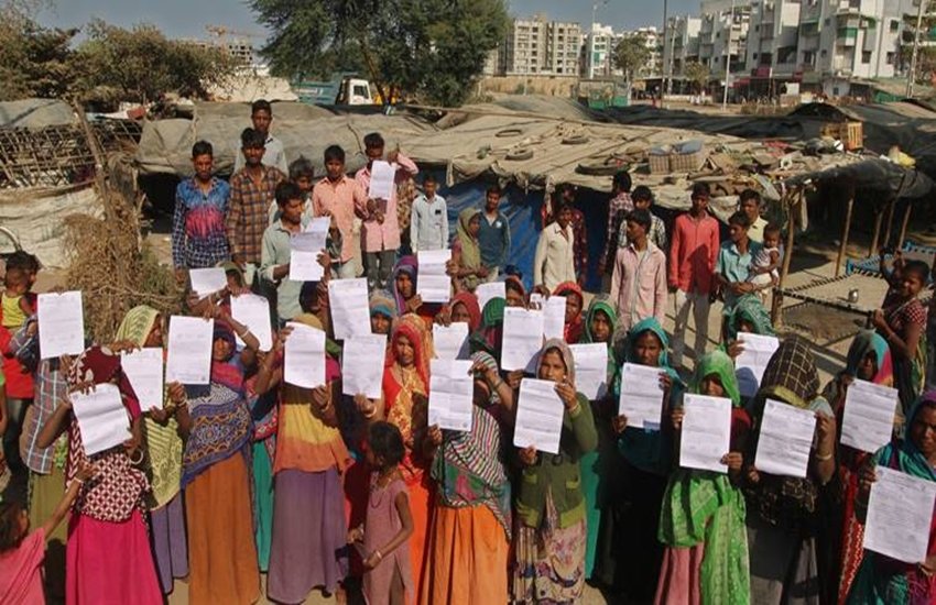 अमेरिकी राष्ट्रपति डोनाल्ड ट्रम्प के अहमदाबाद दौरे से पहले इन झुग्गियों के सामने वाली सड़क पर दीवार बनाई जा रही है। (Photo: REUTERS)