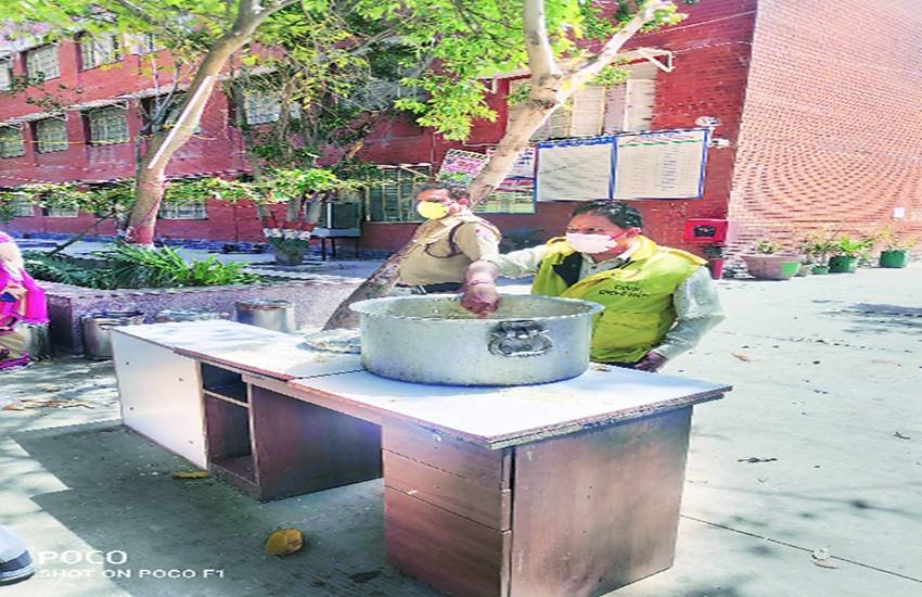 खाना वितरण करते पुलिसकर्मी।