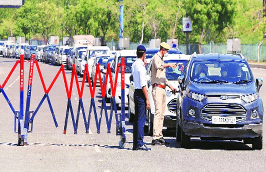 दिल्ली-नोएडा सीमा पर कर्मचारियों की जांच करती पुलिस।
