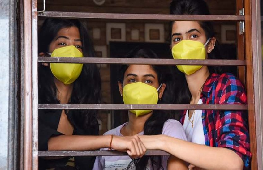 राजस्थान के जोधपुर में लॉकडाउन के बीच मास्क पहनकर घरों से बाहर निहारती लड़कियां। (फोटो-पीटीआई)