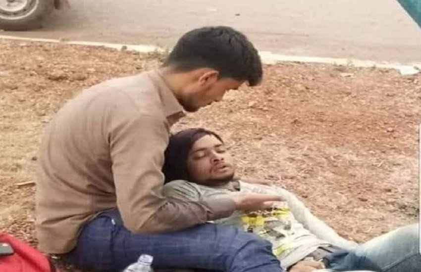 Migrant worker: बीमार अमृत का सिर गोदी में लिए हाईवे किनारे बैठा मोहम्मद याकूब। (viral photo/Facebook)