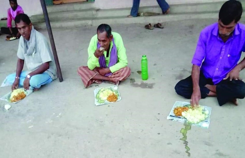 अखबार पर खाना खा रहे इन लोगों की तस्पीर सोशल मीडिया में वायरल हो रही है। (Photo Source: @thealokputul/twitter)
