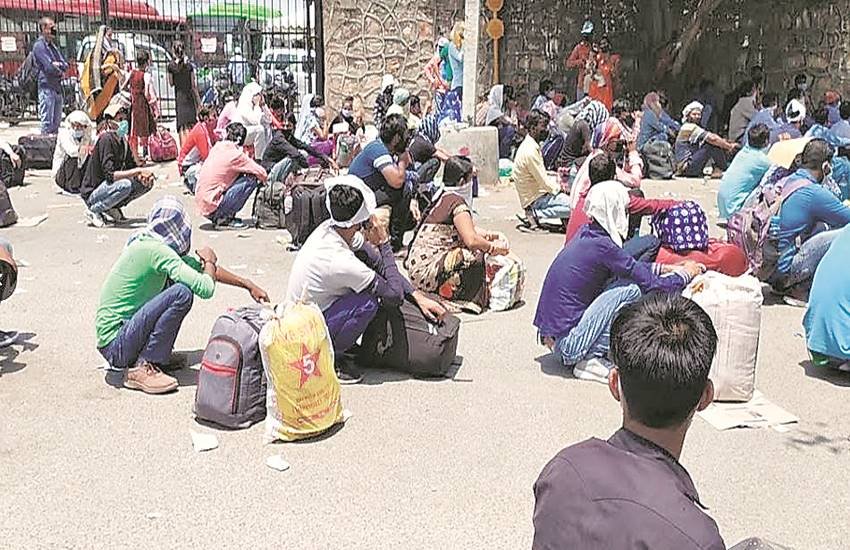 कड़ी धूप में बैठे मजदूर अपनी बारी का इंतजार करते हुए।