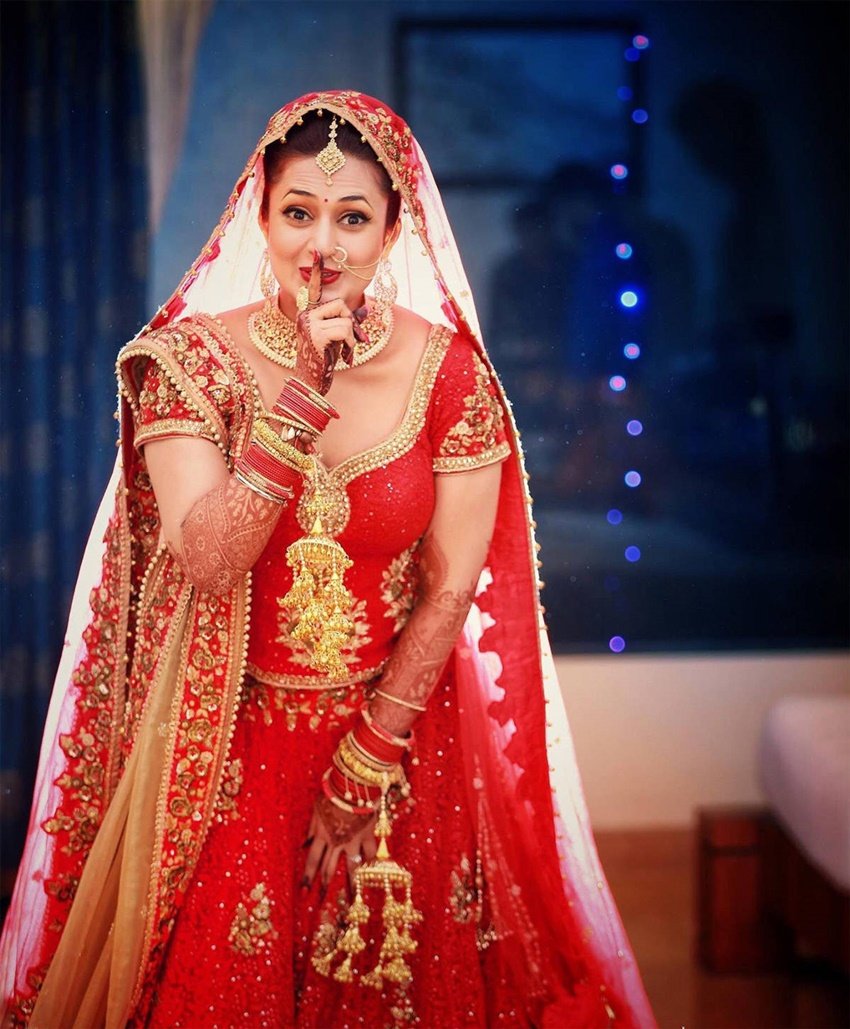 दिव्यांका त्रिपाठी ने अपनी शादी में सिंदूरी लाल रंग का लहंगा पहना था। ये रंग उनपर काफी जच रहा था। दुल्हन के लिबास में दिव्यांका और ज्यादा सुंदर दिख रही थीं।