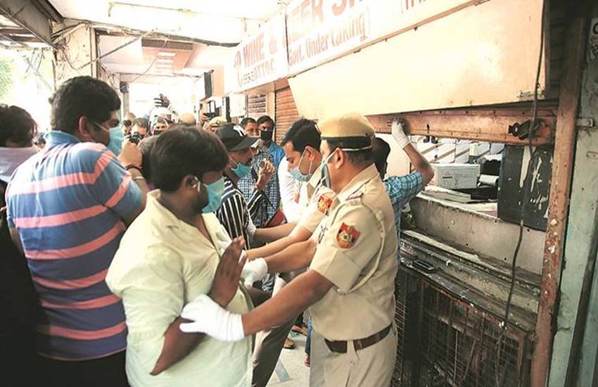 शराब की दुकान पर जुटी भीड़ और उनको नियंत्रित करती पुलिस।