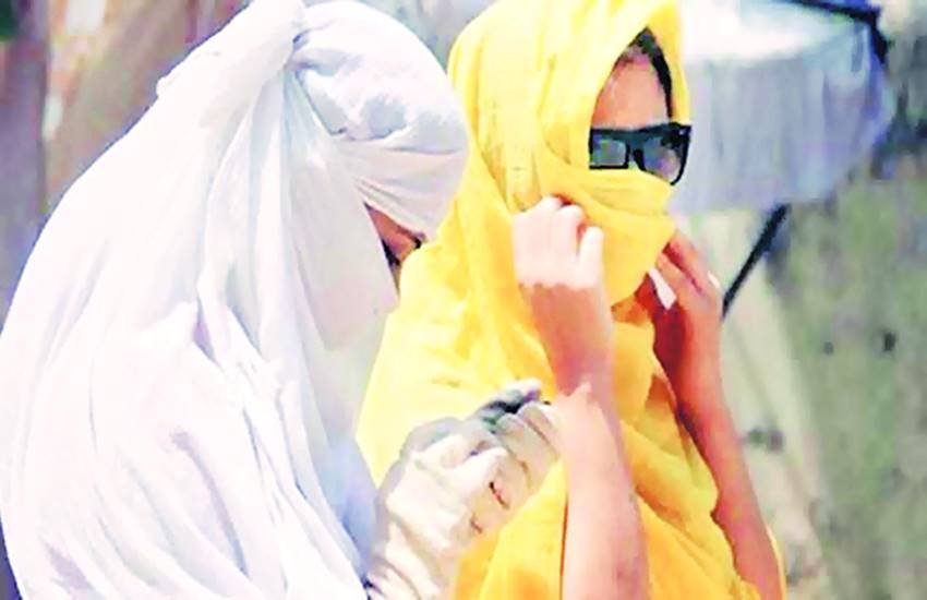 धूप और लू से बचने के लिए मुंह को कपड़ों से कवर करके घर से निकलीं युवतियां।