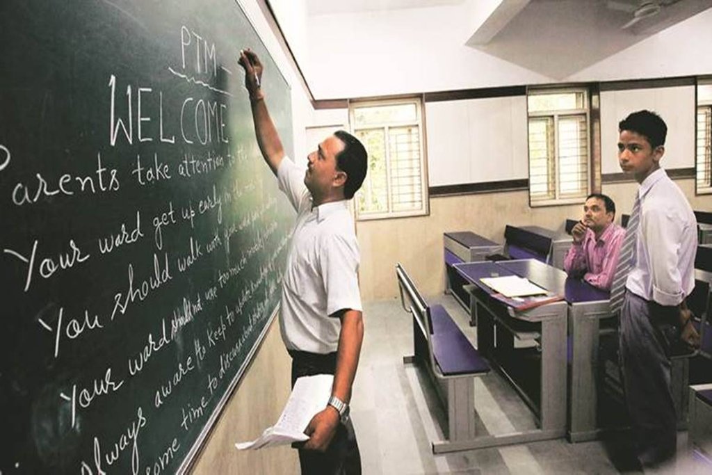 कक्षा में बच्चों को पढ़ाते शिक्षक। 