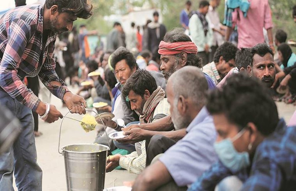 कोरोना काल में भोजन करने के लिए जद्दाेेजहद करते लोग। फाइल फोटो।