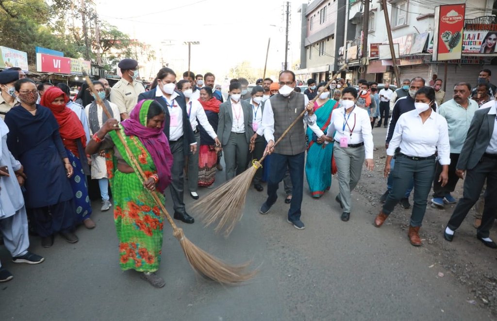 woman officer protect shivraj, shivraj talks to woman scavengers, shivraj sweeps road with scavengers, shivraj singh chauhan on womans day, shivraj on road with scavengers, female officer security to shivraj,