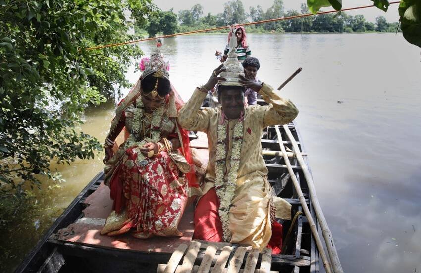 भारी बारिश और बाढ़ के कारण एक नवविवाहित जोड़े को घर जाने के लिए नाव की सवारी करनी पड़ी।