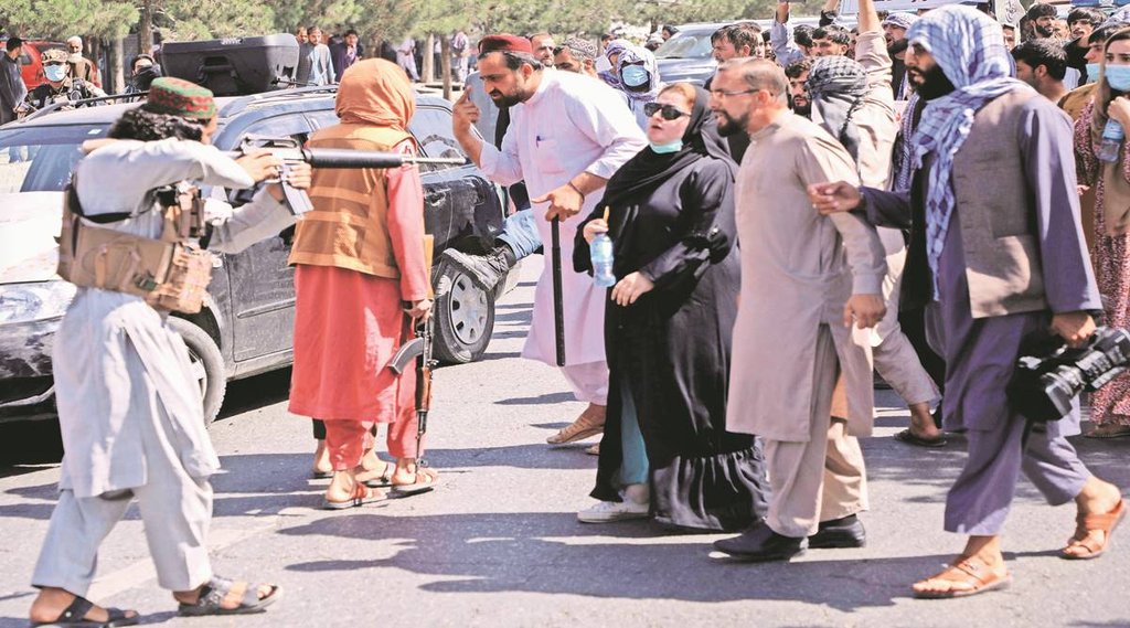 काबुल में पाकिस्तान के खिलाफ प्रदर्शन कर रहे लोगों पर बंदूक ताने खड़ा तालिबानी। फोटो- रॉयटर्स