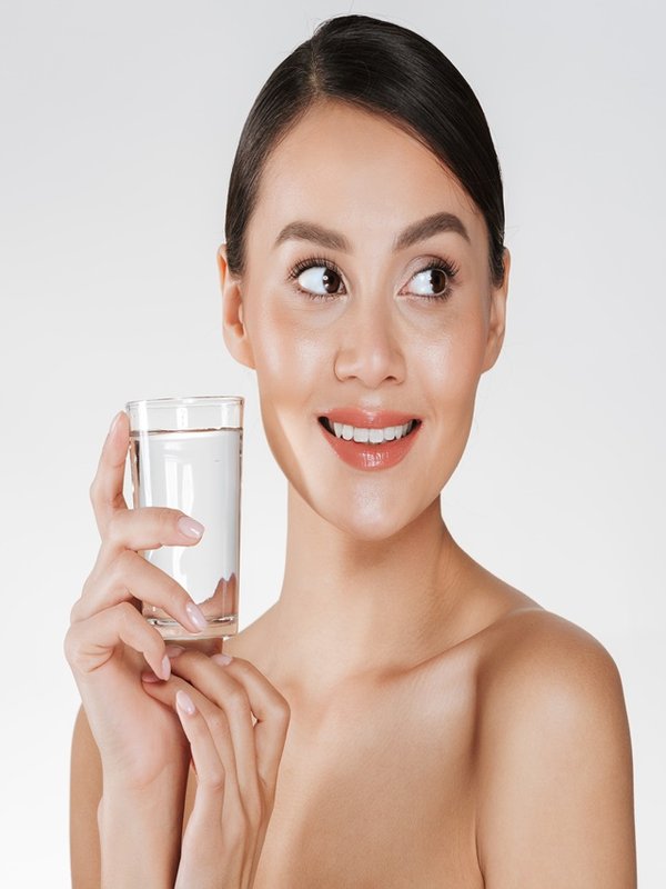 Beauty portrait of young happy woman with hair in bun drinking s