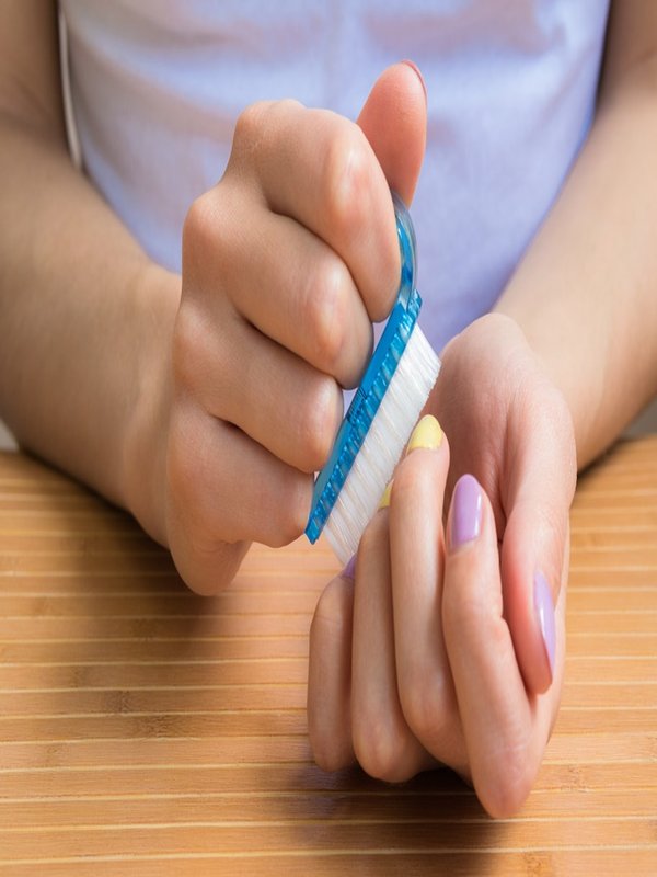 Female hands holding a nail brush