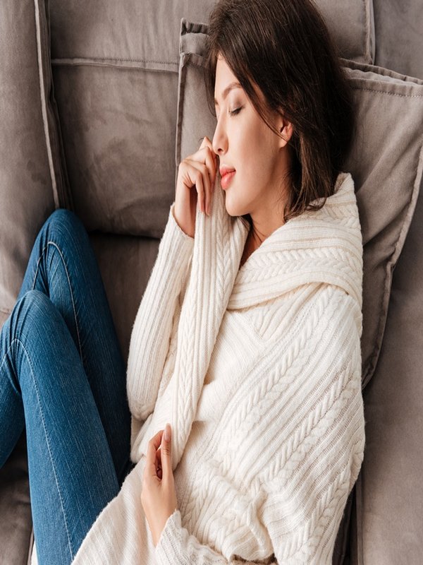 Peaceful cute young woman sleeping on sofa