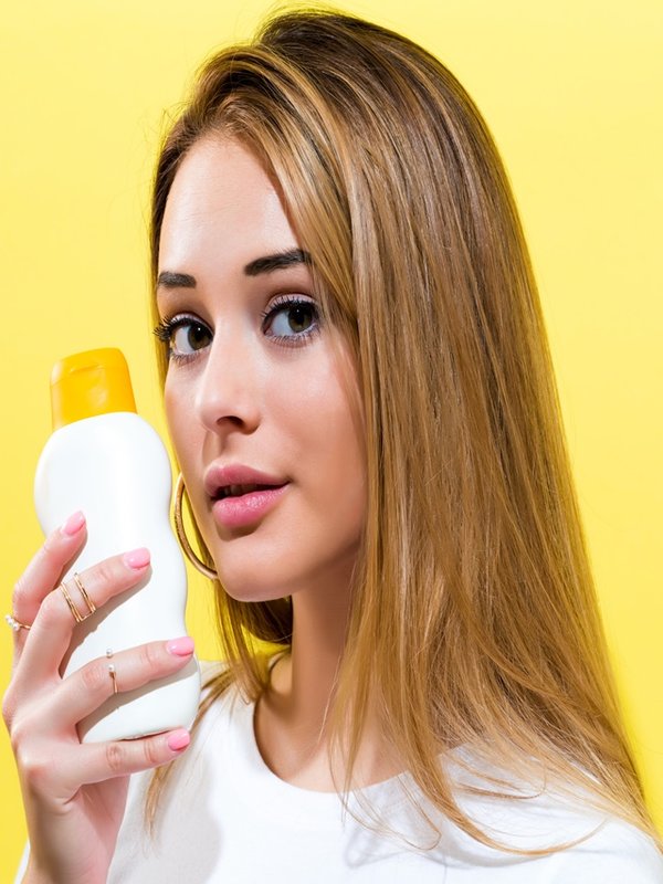 Young woman a bottle of sunblock