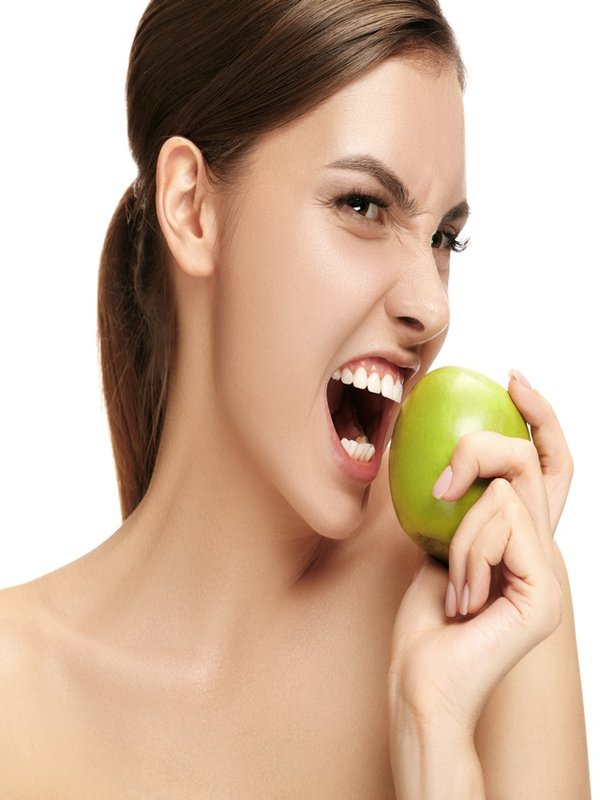 portrait of attractive caucasian smiling woman isolated on white studio shot eating green apple