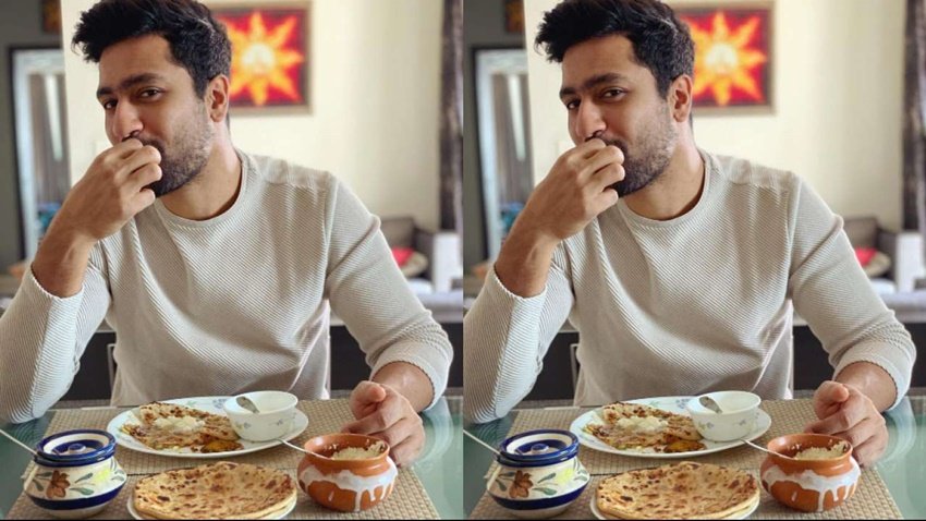 लिविंग कम डाइनिंग रूम  की दीवारों पर बेहतरीन आर्ट वर्क वाली पेंटिंग्स नजर आती हैं। कमरे में खिड़की से बाहर की प्राकृतिक रोशनी आती है।