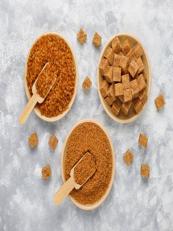 Various types of brown sugar on concrete background,top view