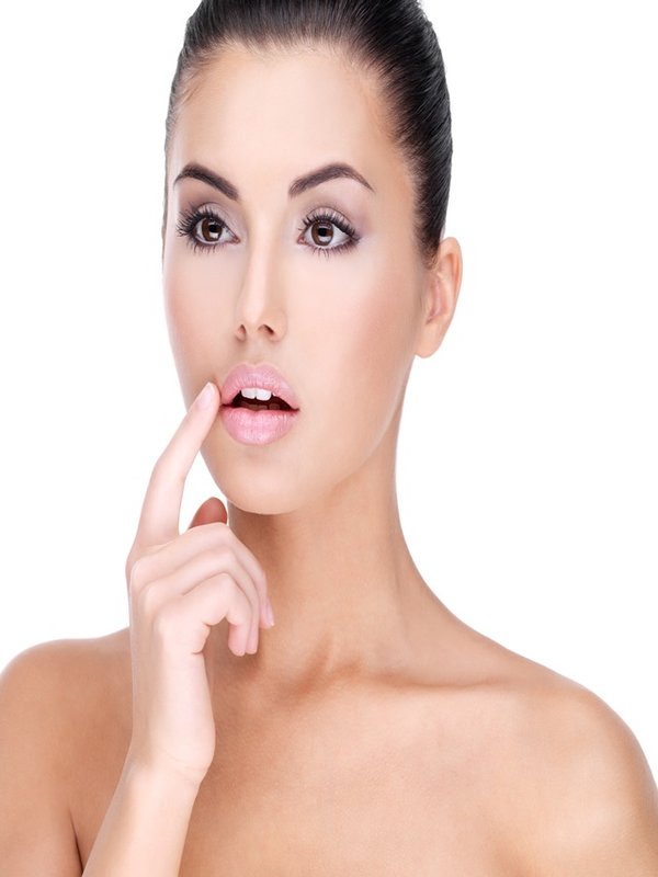 Face of a Pretty young woman with finger at lips - on white background